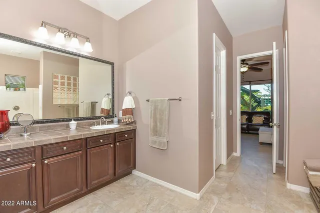 a spacious bathroom with a granite countertop sink and a mirror