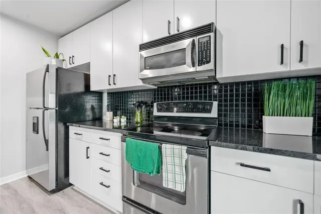 a kitchen with stainless steel appliances a microwave and cabinets