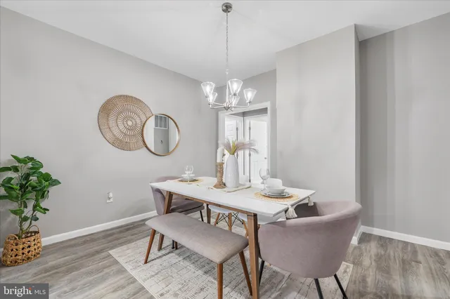 a dining room with furniture a potted plant and wooden floor