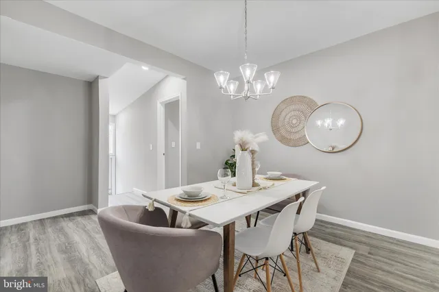a view of a dining room with furniture a chandelier and wooden floor