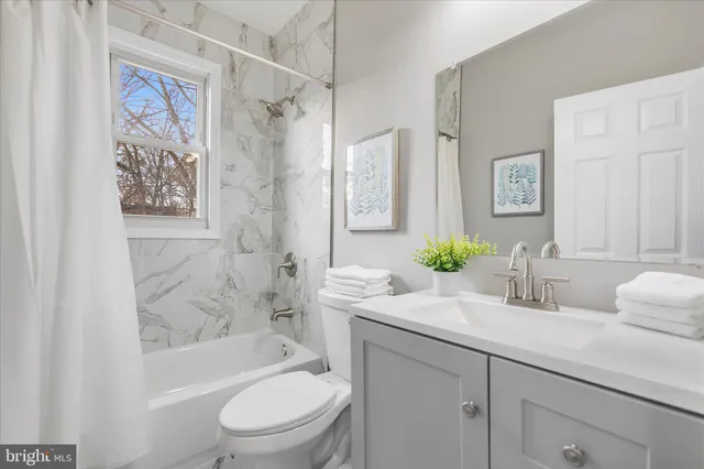 a bathroom with a granite countertop sink a toilet and bathtub