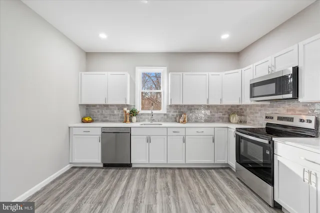 a kitchen with sink cabinets and microwave