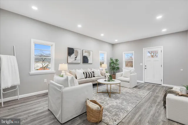 a living room with furniture and a wooden floor