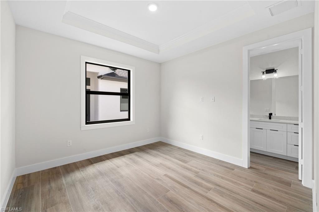 3049 Pine Tree Drive Naples, FL 34112 - Photo 11 of 38 an empty room with a window and wooden floor