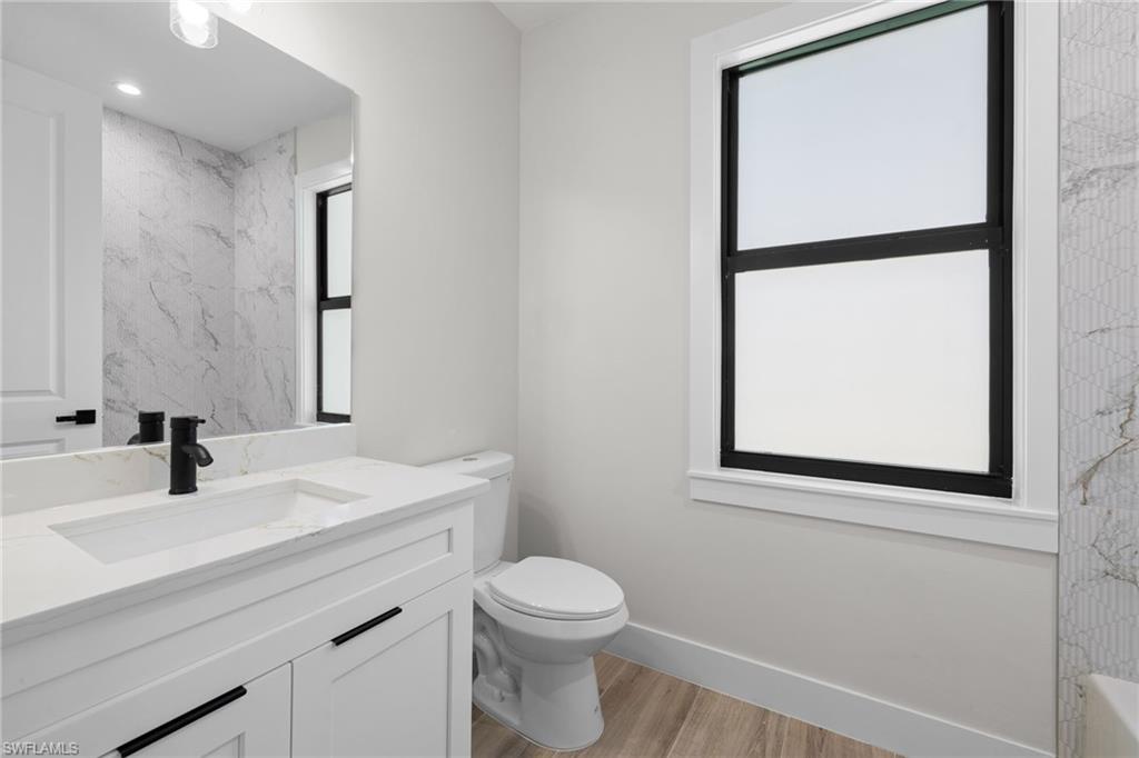 3049 Pine Tree Drive Naples, FL 34112 - Photo 12 of 38 a bathroom with a sink toilet and mirror