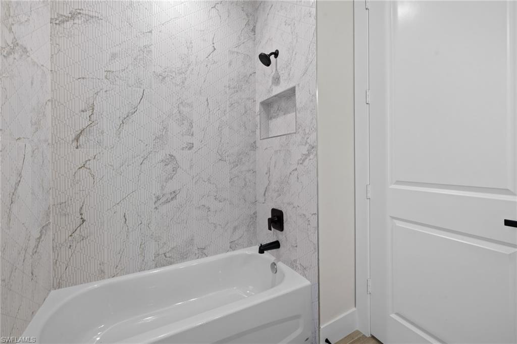 3049 Pine Tree Drive Naples, FL 34112 - Photo 13 of 38 a bathroom with a bathtub