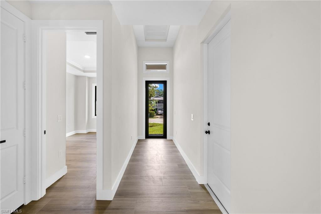 3049 Pine Tree Drive Naples, FL 34112 - Photo 16 of 38 a view of a hallway with wooden floor