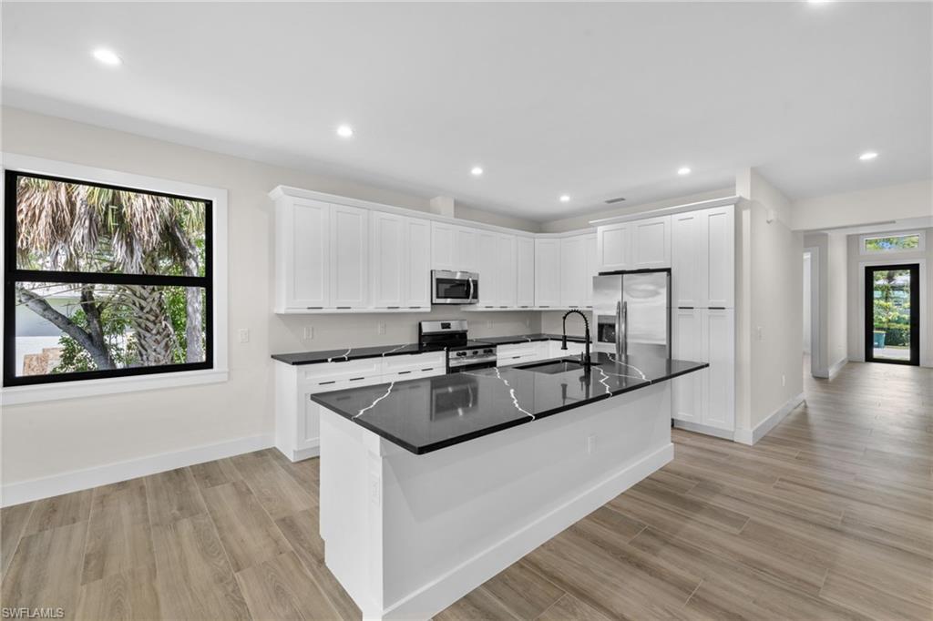 3049 Pine Tree Drive Naples, FL 34112 - Photo 19 of 38 a kitchen with stainless steel appliances granite countertop a sink and a stove