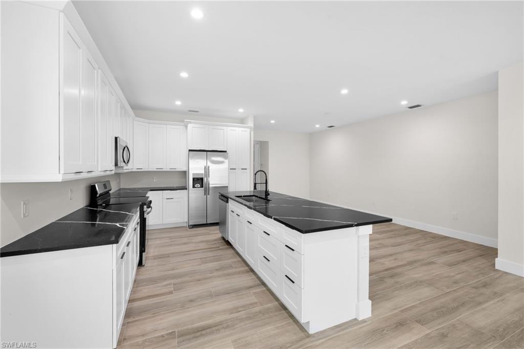 3049 Pine Tree Drive Naples, FL 34112 - Photo 21 of 38 a large kitchen with stainless steel appliances granite countertop a large counter top a sink and a stove top oven