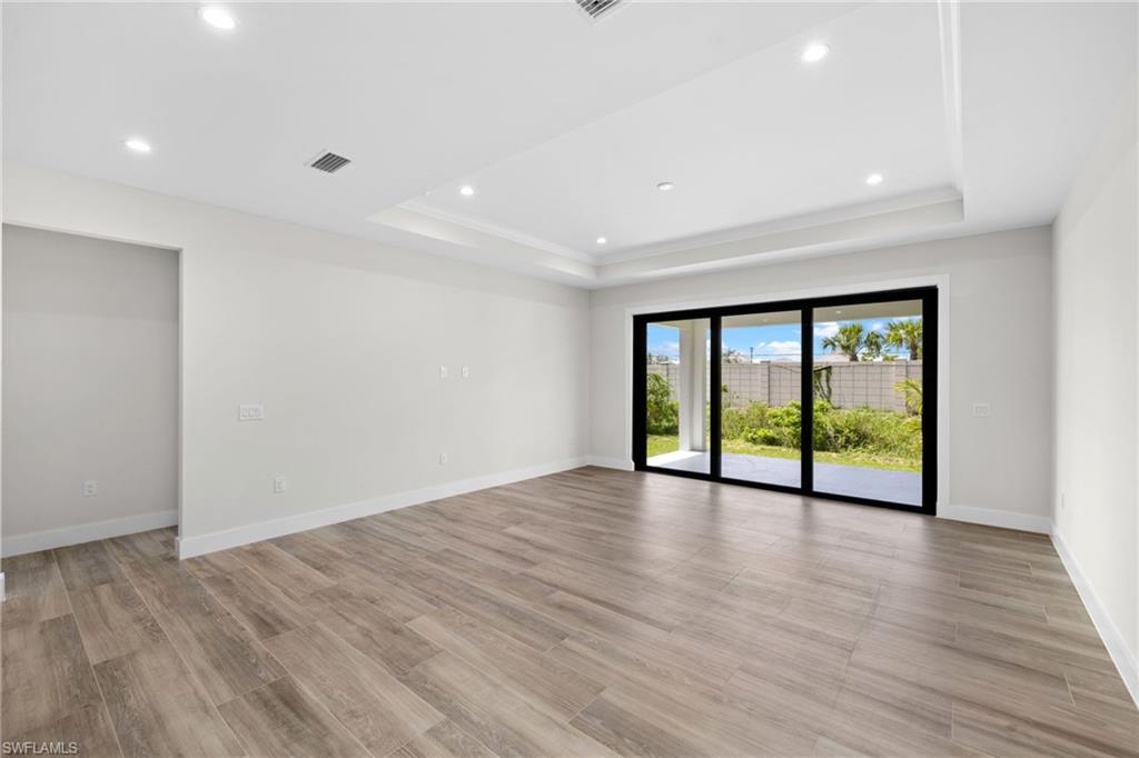3049 Pine Tree Drive Naples, FL 34112 - Photo 22 of 38 a view of an empty room with wooden floor and a window