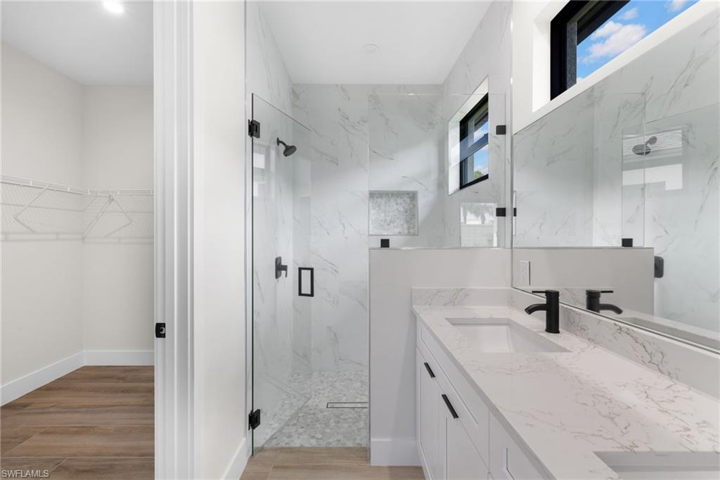 3049 Pine Tree Drive Naples, FL 34112 - Photo 5 of 38 a bathroom with a sink a toilet and shower