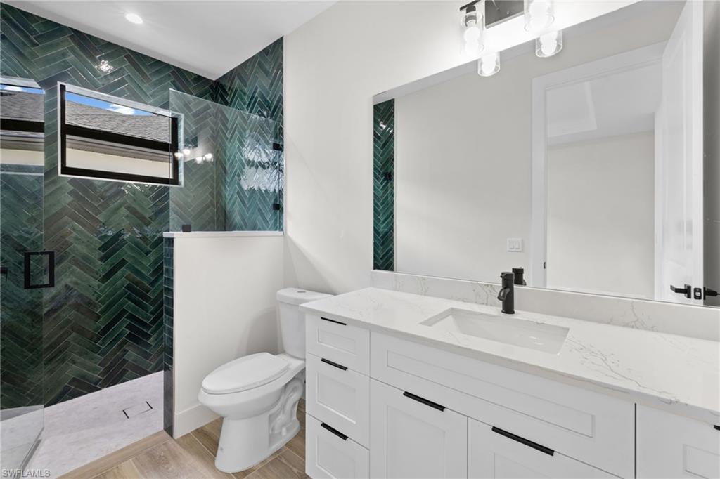 3049 Pine Tree Drive Naples, FL 34112 - Photo 9 of 38 a bathroom with a sink toilet and shower