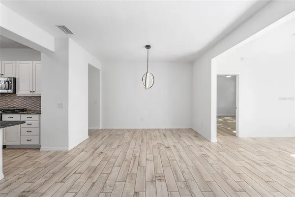 a view of a room with wooden floor and cabinets