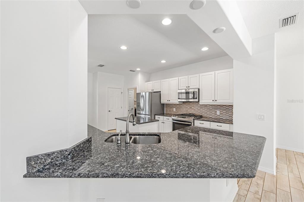 4970 Northwest 35th Ln Road Ocala, FL 34482 - Photo 14 of 41 a kitchen with stainless steel appliances granite countertop a sink stove and refrigerator