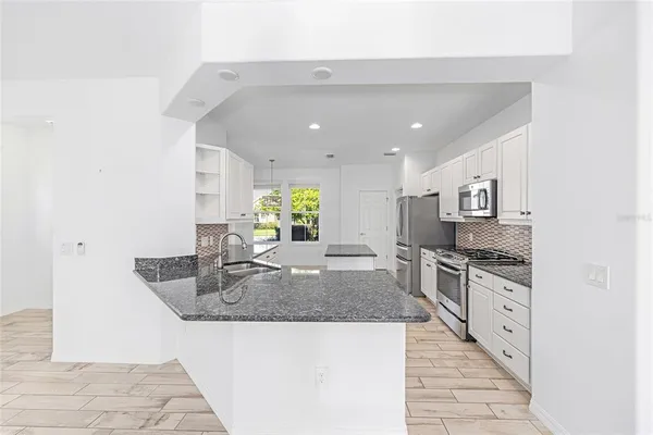 a kitchen with stainless steel appliances granite countertop a sink and a stove