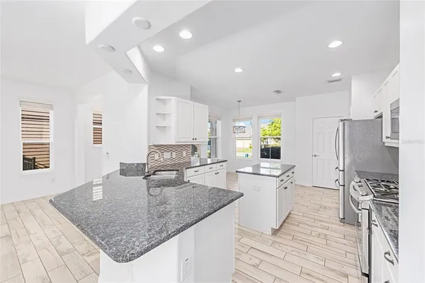 a kitchen with stainless steel appliances granite countertop a sink stove and refrigerator