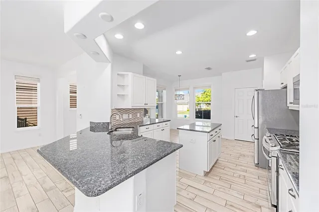 a kitchen with stainless steel appliances granite countertop a sink stove and refrigerator