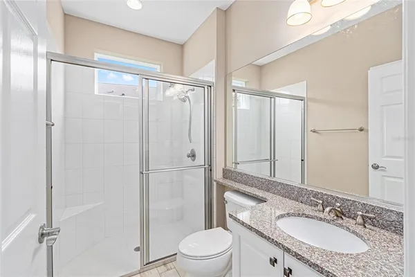 a bathroom with a granite countertop sink toilet and shower