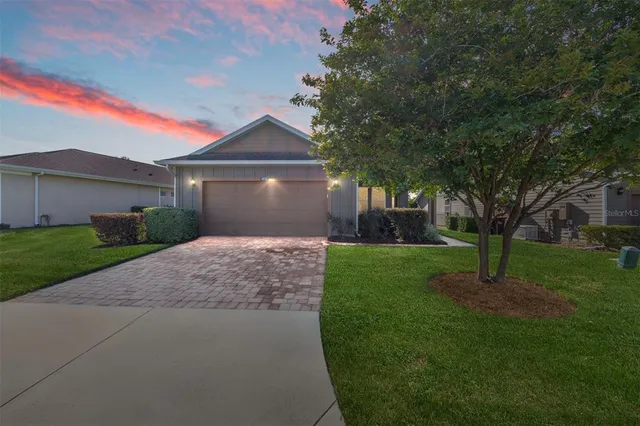 a front view of a house with a garden and trees