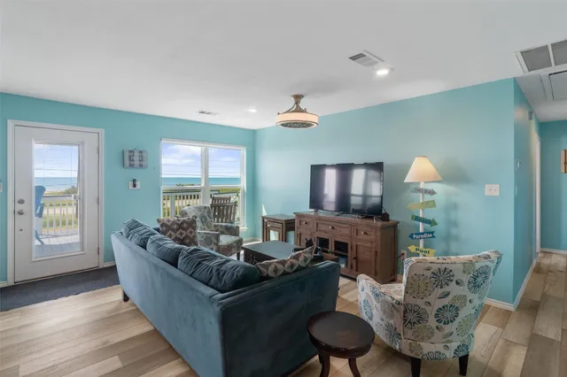a living room with furniture and a view of kitchen