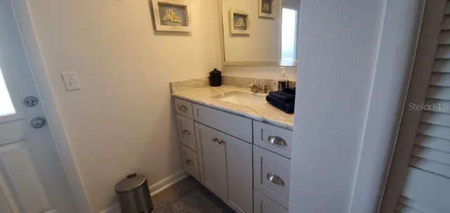 a bathroom with a granite countertop sink and a mirror