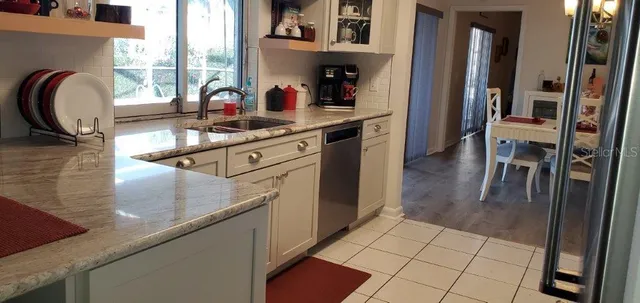 a kitchen with stainless steel appliances granite countertop a sink a stove and a refrigerator
