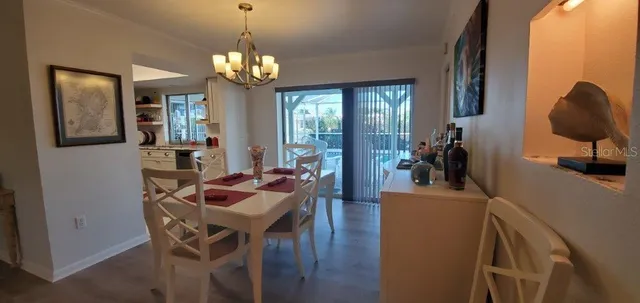 a dining room with furniture a chandelier and wooden floor