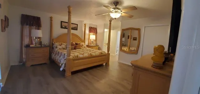 a bedroom with bed and wooden floor