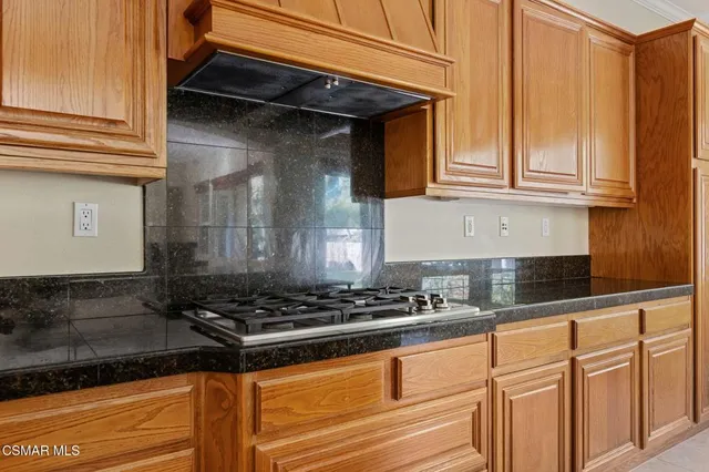 a kitchen with granite countertop a stove and cabinets