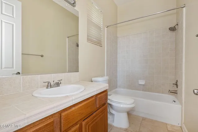 an empty room with windows and ceiling fan