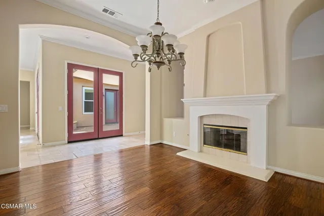 a view of a livingroom with wooden floor a fireplace and windows