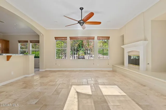 an empty room with windows and fireplace