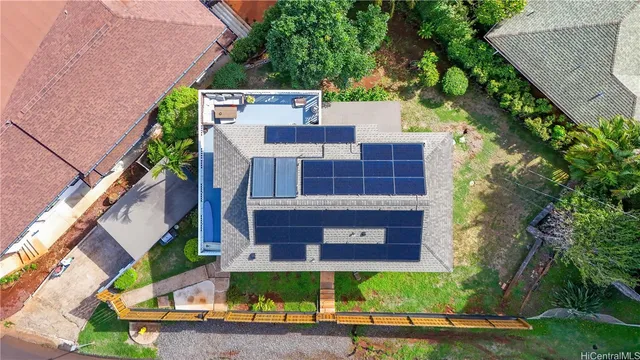 aerial view of a house with a yard and large tree