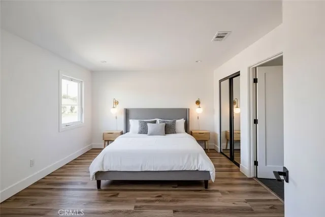 a bedroom with a bed and wooden floor
