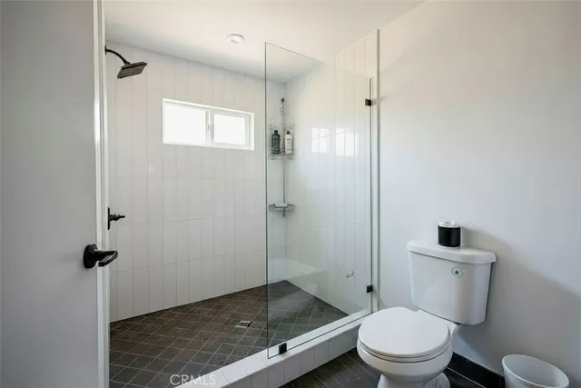 a bathroom with a granite countertop toilet a sink and shower