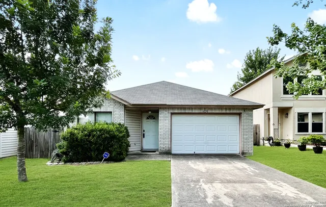 a front view of a house with yard and green space