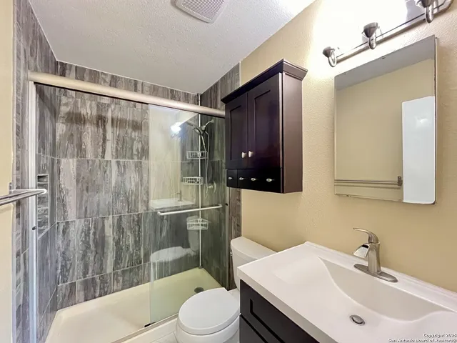 a bathroom with a sink toilet and shower