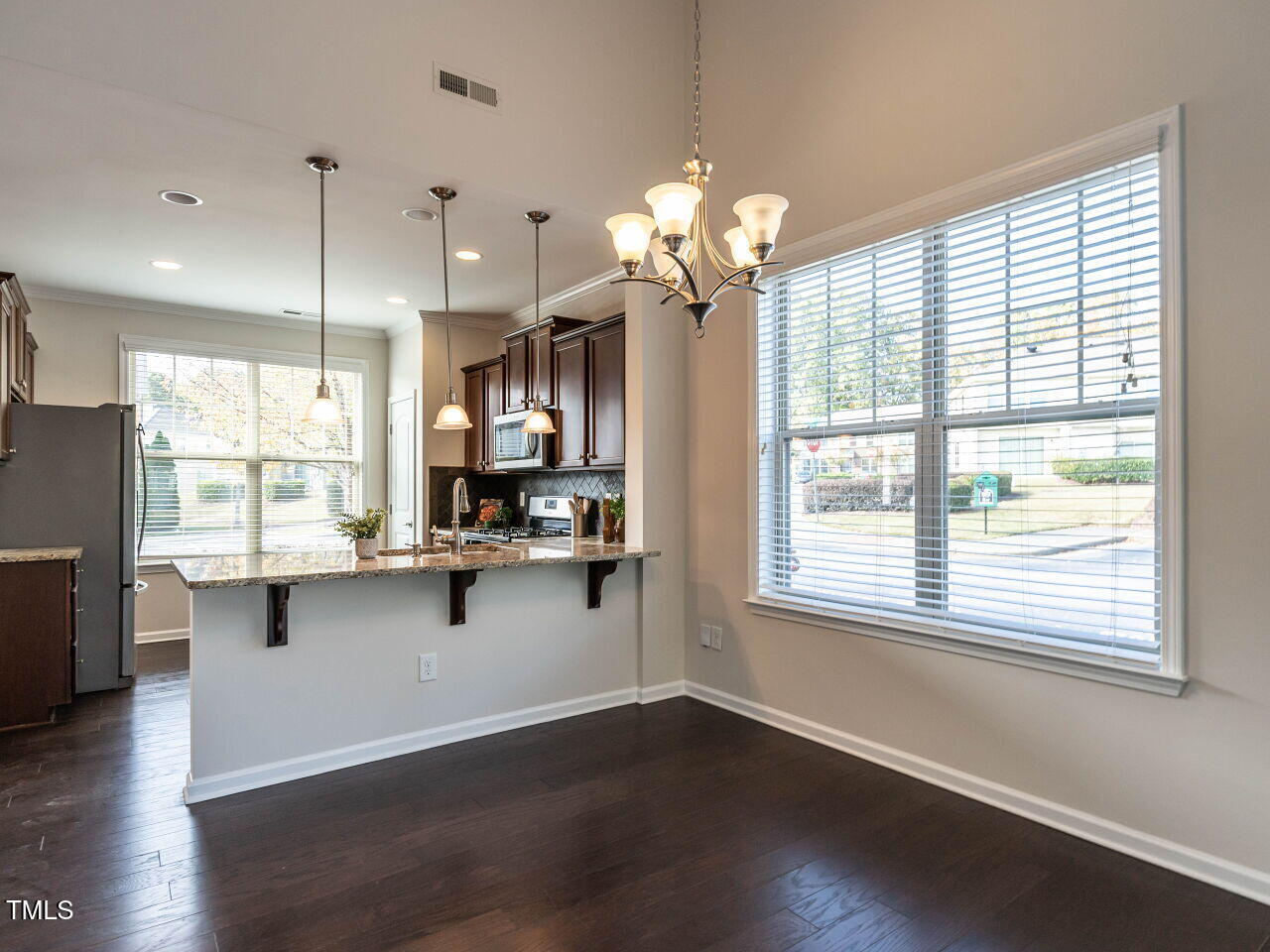 11 St Elias Drive Durham, NC 27705 - Photo 15 of 34 a open kitchen with stainless steel appliances granite countertop a refrigerator a sink dishwasher a stove and a large window