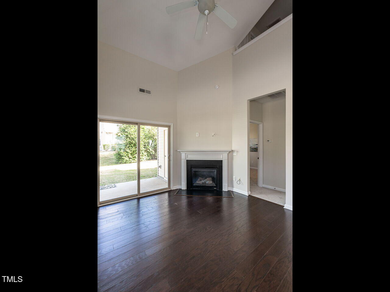 11 St Elias Drive Durham, NC 27705 - Photo 17 of 34 a view of an empty room with a fireplace and wooden floor