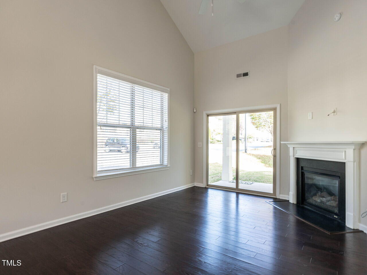 11 St Elias Drive Durham, NC 27705 - Photo 18 of 34 an empty room with wooden floor and fireplace