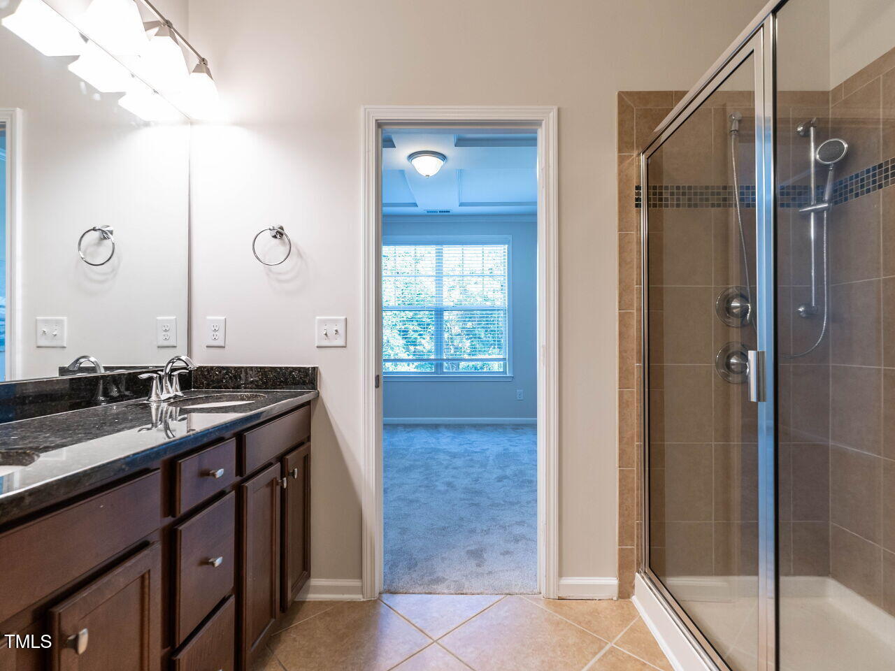 11 St Elias Drive Durham, NC 27705 - Photo 25 of 34 a bathroom with a granite countertop sink a mirror and a shower