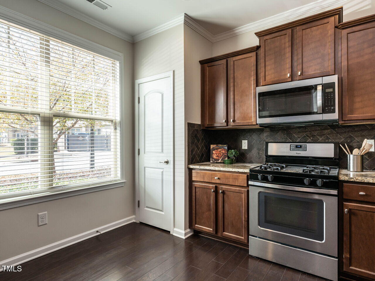 11 St Elias Drive Durham, NC 27705 - Photo 9 of 34 a kitchen with stainless steel appliances wooden cabinets and a stove top oven