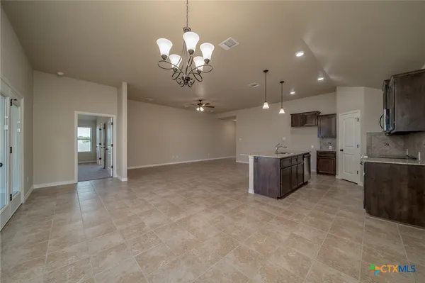 a view of a kitchen with a sink and chandelier