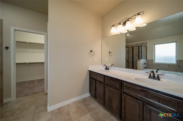 a bathroom with a double vanity sink and a mirror