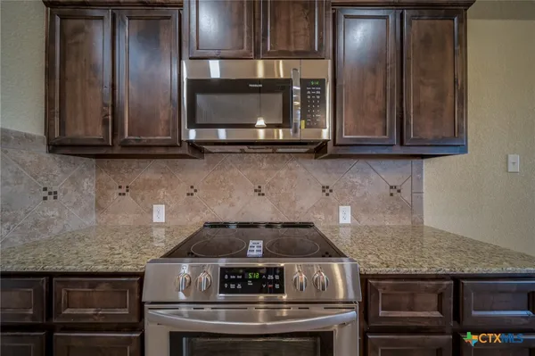 a stove top oven sitting inside of a kitchen