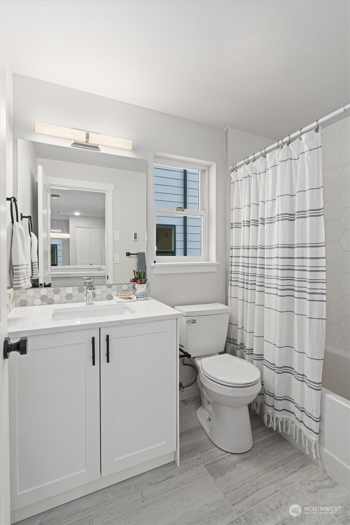 2412 Northwest 64th Street Seattle, WA 98107 - Photo 26 of 31 a bathroom with a granite countertop toilet a sink and a mirror