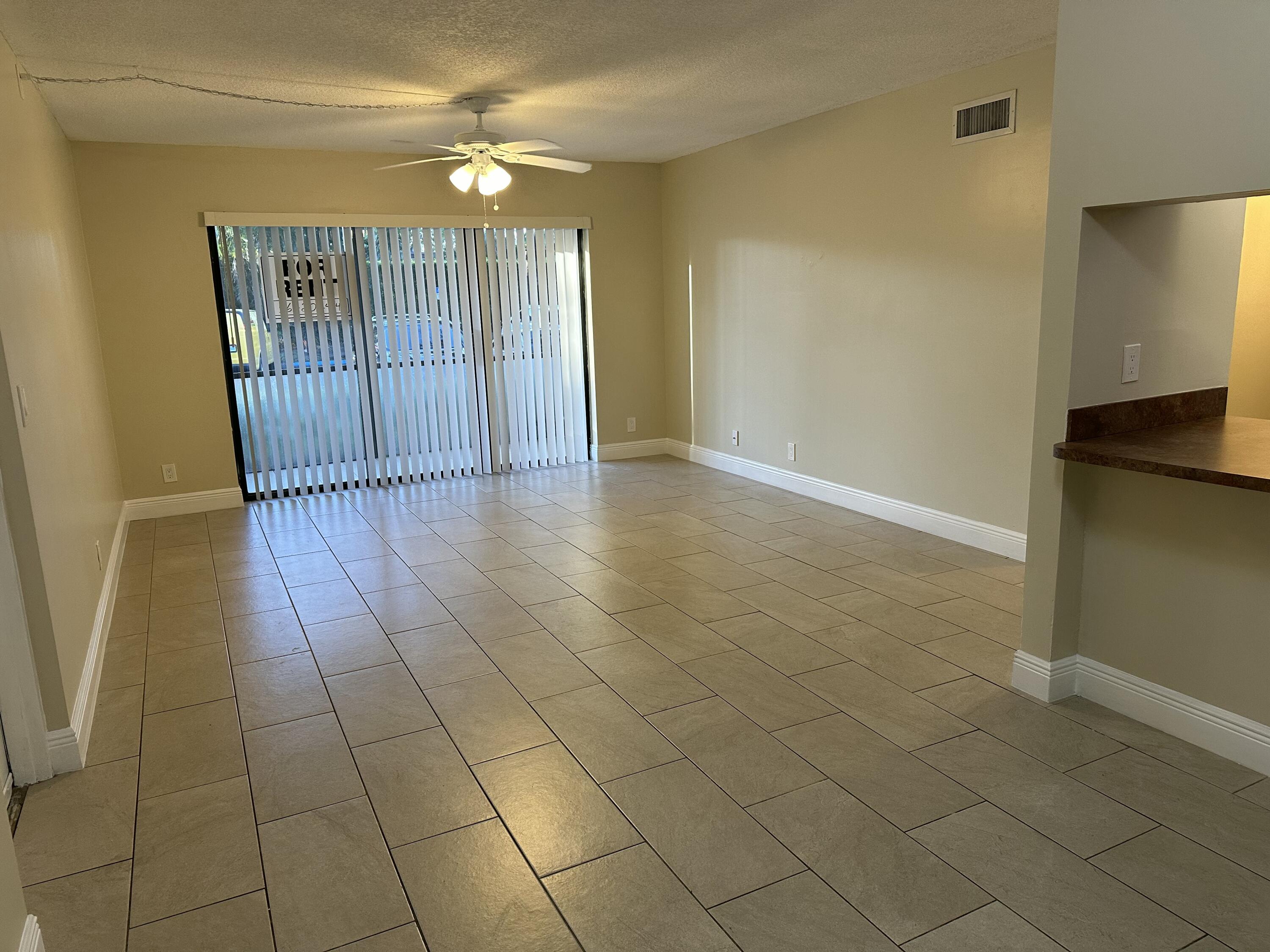 202 Foxtail Drive, Unit A1 Greenacres, FL 33415 - Photo 2 of 10 a view of an empty room with window and chandelier fan