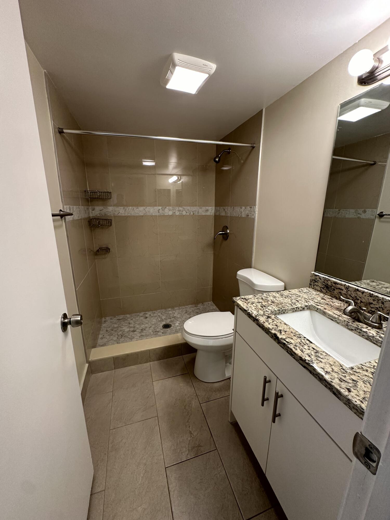202 Foxtail Drive, Unit A1 Greenacres, FL 33415 - Photo 8 of 10 a bathroom with a granite countertop sink toilet and shower
