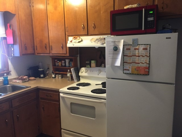 1121 Carlton Avenue Raleigh, NC 27606 - Photo 9 of 14 a kitchen with stainless steel appliances a stove a sink and a microwave