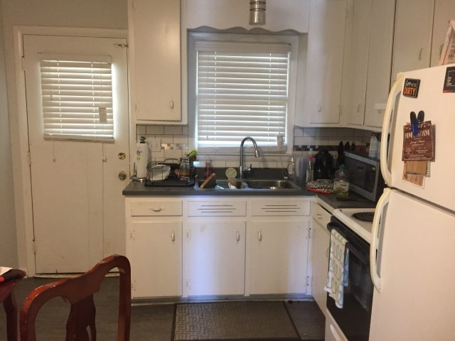 1121 Carlton Avenue Raleigh, NC 27606 - Photo 10 of 14 a kitchen with stainless steel appliances white cabinets and a window